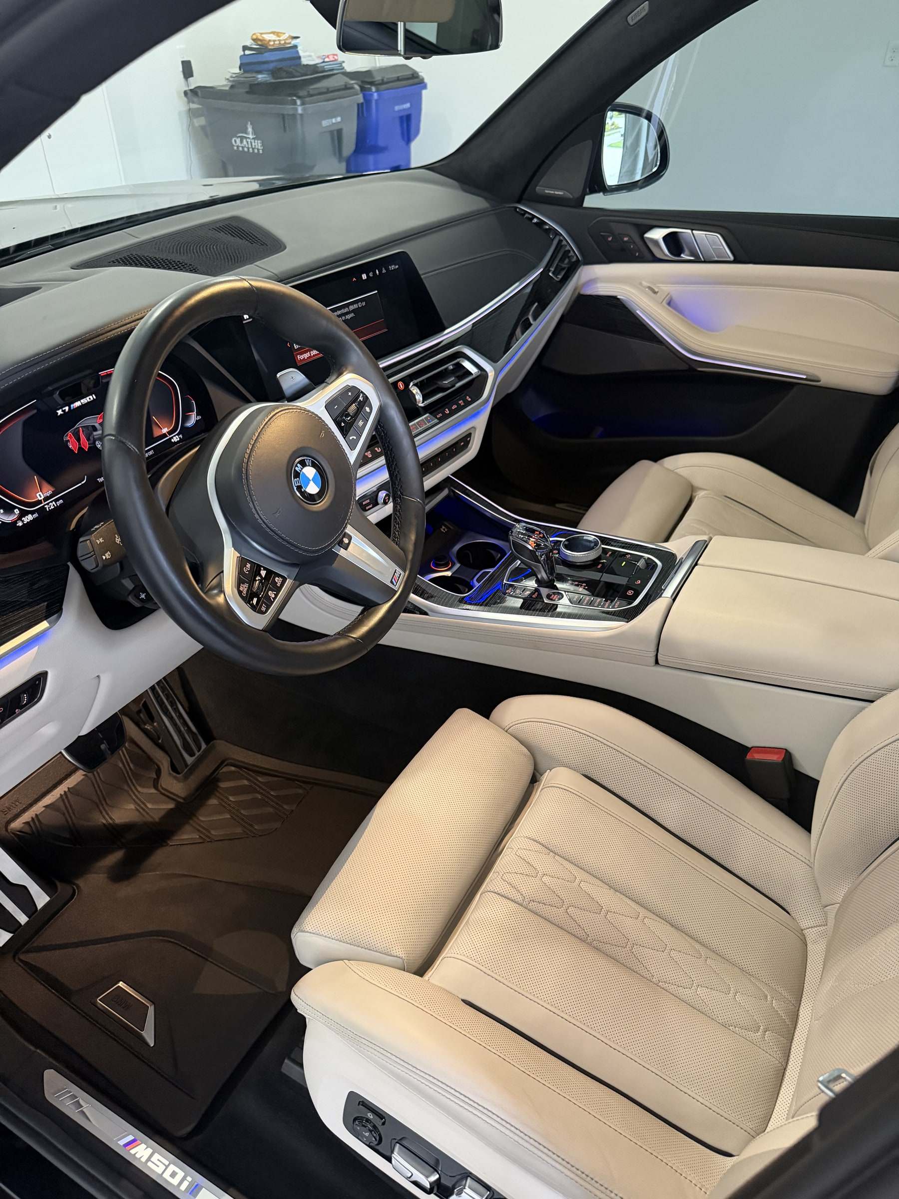Clean beige leather seats, steering wheel, and dash inside a BMW X5 after a Takumi detail