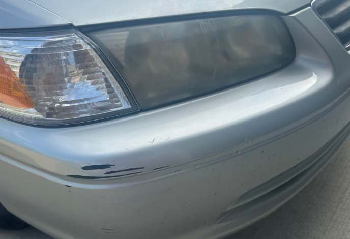 Hazy, oxidized headlight on a silver Toyota Camry before restoration