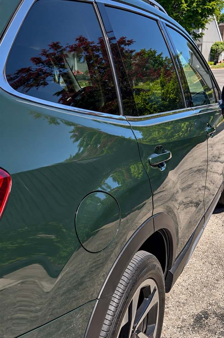 The same green SUV after an exterior detail, with clean, glossy paint