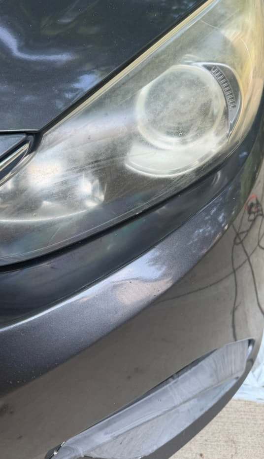Yellowed, cloudy headlight on a gray Hyundai before restoration