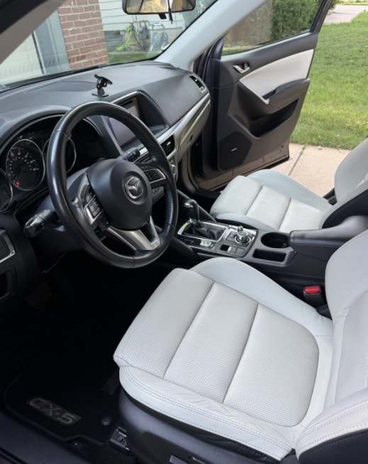 Front seats and dash of a Mazda CX-5 with white leather