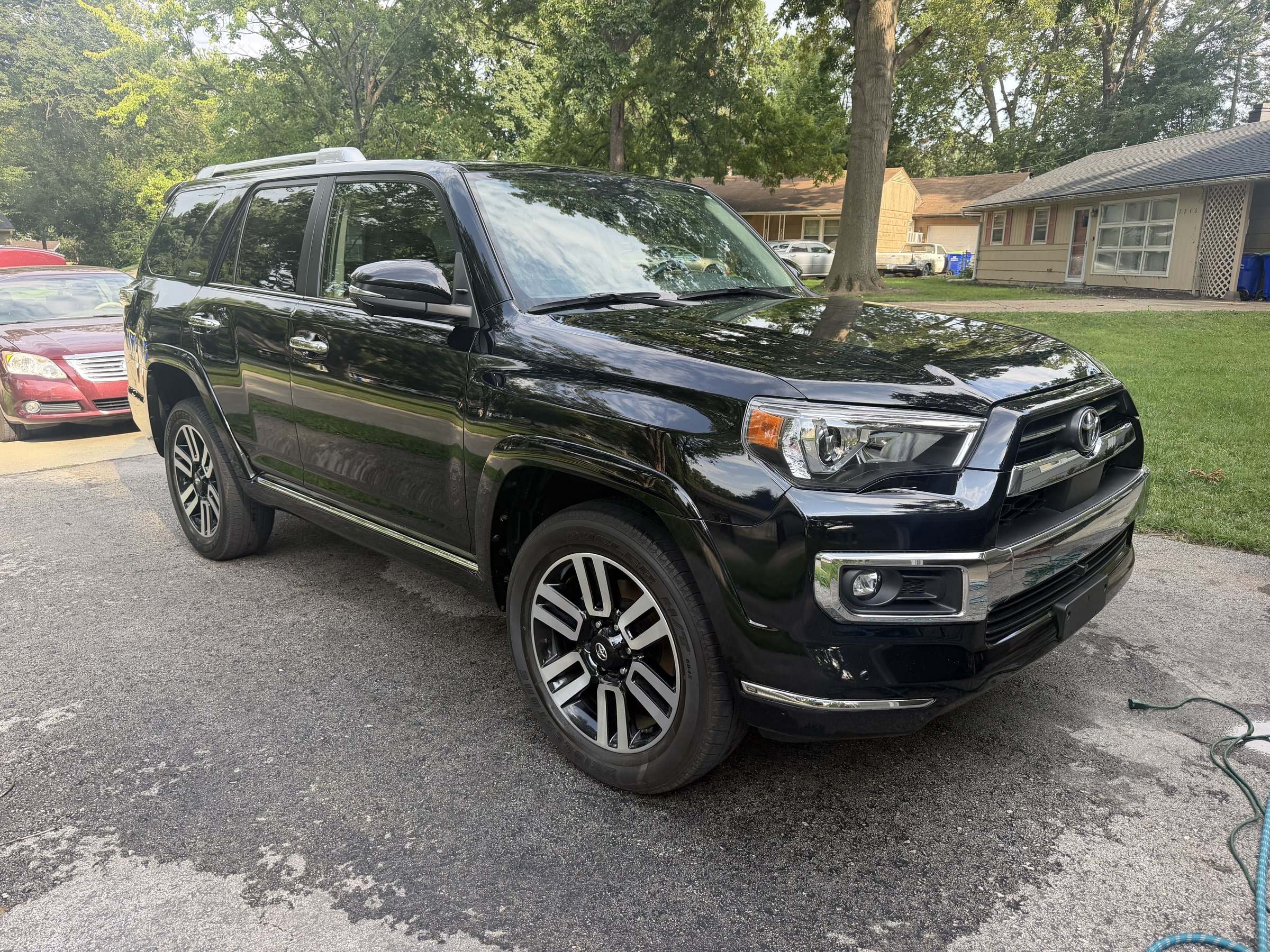 Black Toyota 4Runner on a freshly rinsed driveway after a Takumi mobile detail