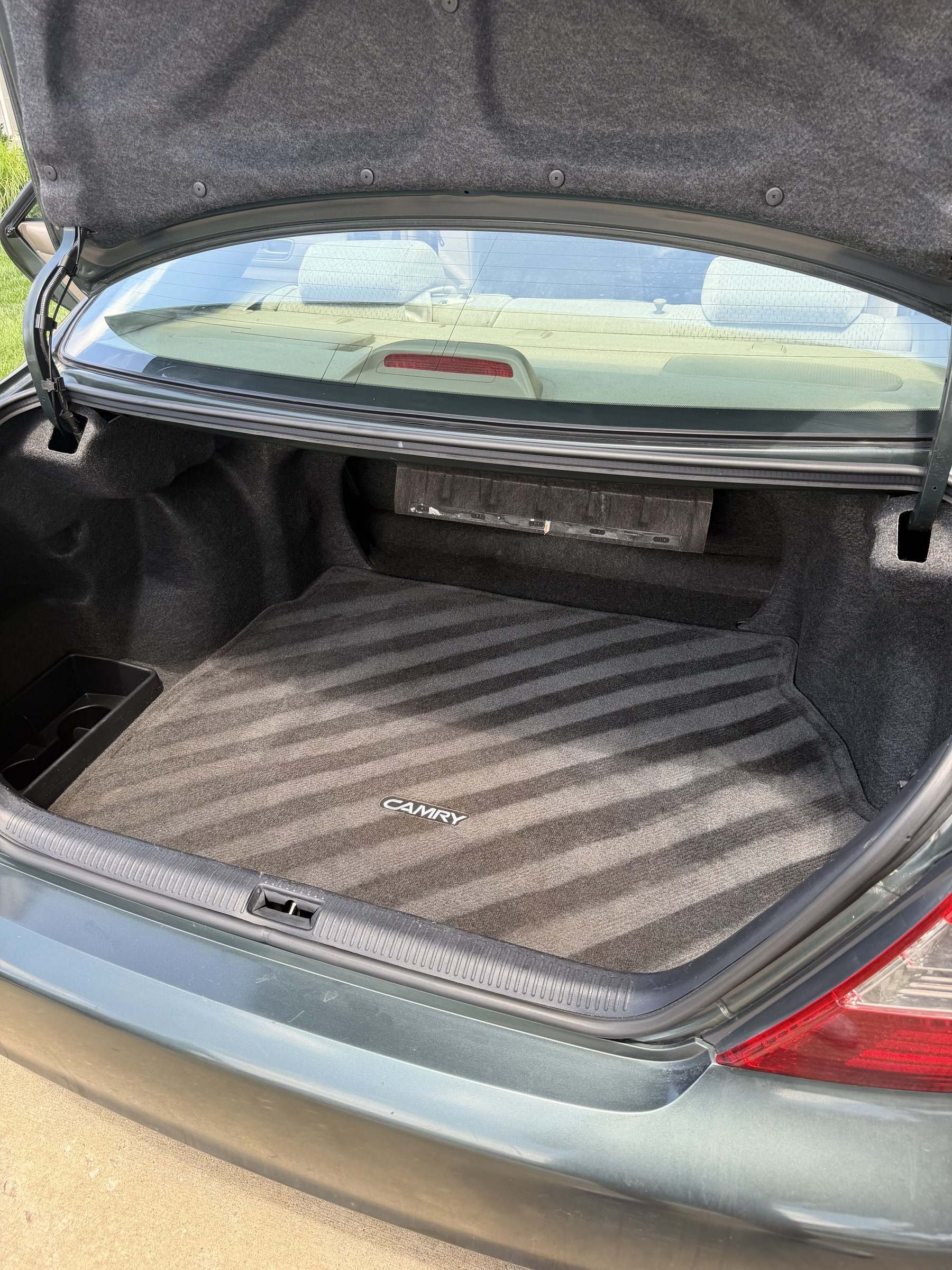 Clean carpeted trunk of a Toyota Camry with fresh vacuum lines